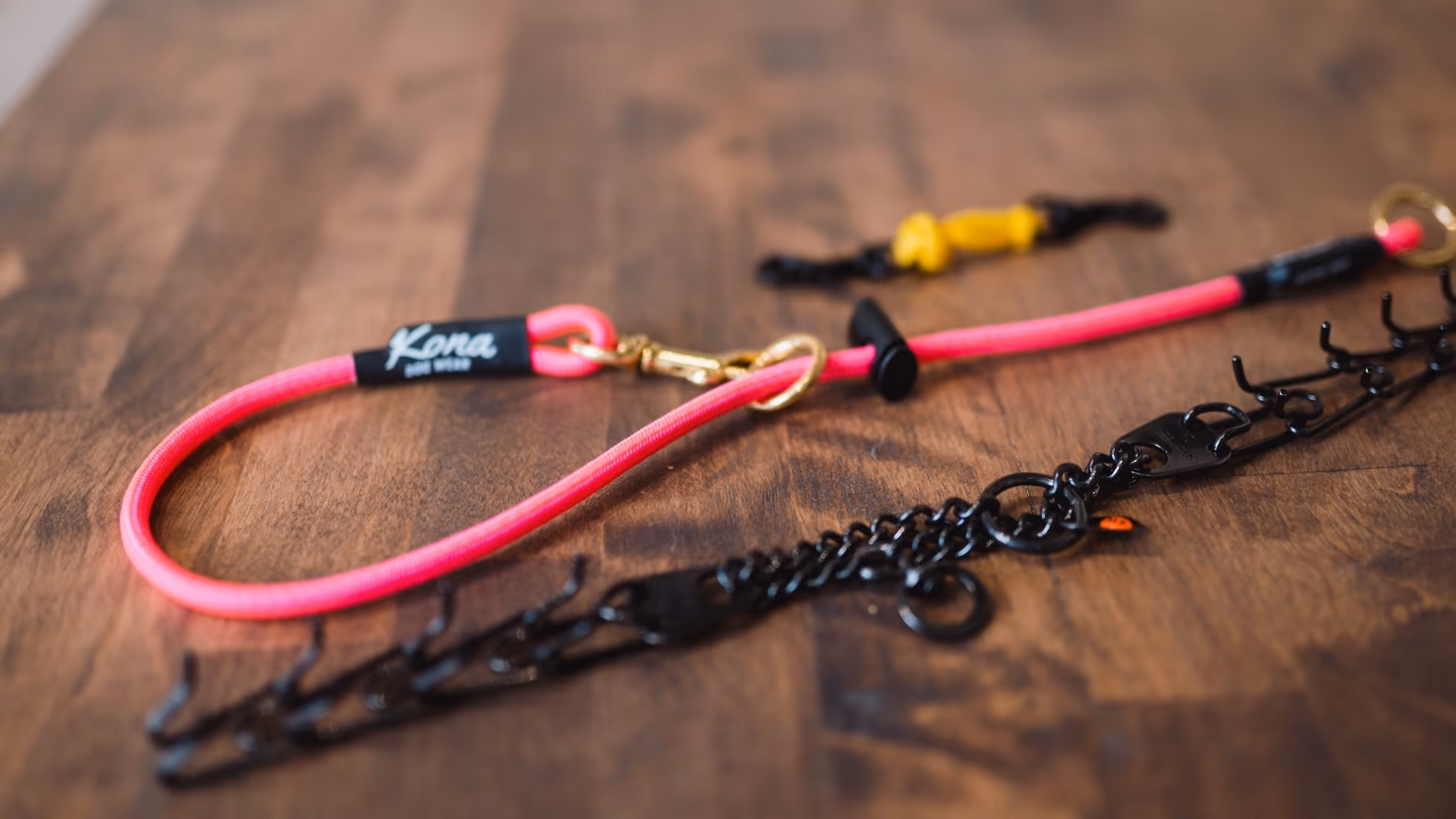Picture of a Prong Collar, Safety Collar, and Safety Clip laid flat on a table